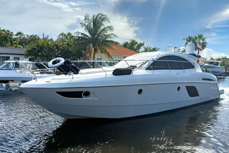  Yacht Photos Pics 2015 Beneteau Gran Turismo 49 yacht docked, surrounded by palm trees and clear skies.