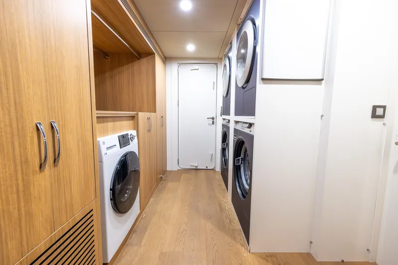 Evelyn P Yacht Photos Pics Laundry room in 2022 Numarine 37XP yacht with modern appliances and wooden cabinetry.