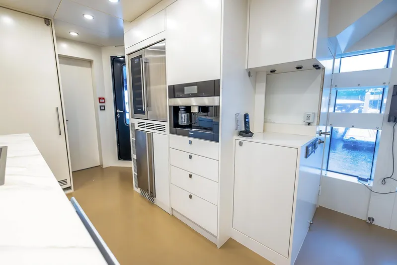 Evelyn P Yacht Photos Pics Modern kitchen interior on 2022 Numarine 37XP yacht, featuring sleek white cabinetry and appliances.