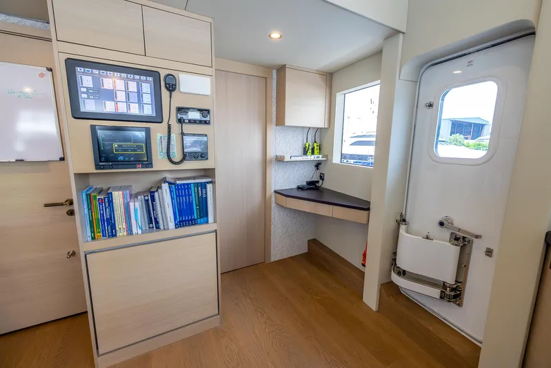 Evelyn P Yacht Photos Pics Modern interior of 2022 Numarine 37XP yacht with control panel and bookshelves.