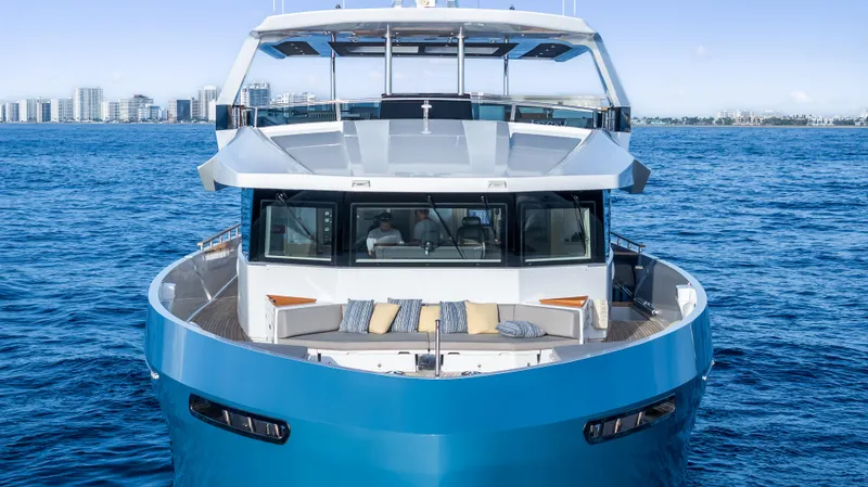 Evelyn P Yacht Photos Pics Numarine 37XP 2022 yacht on ocean, city skyline in background, luxury maritime design.