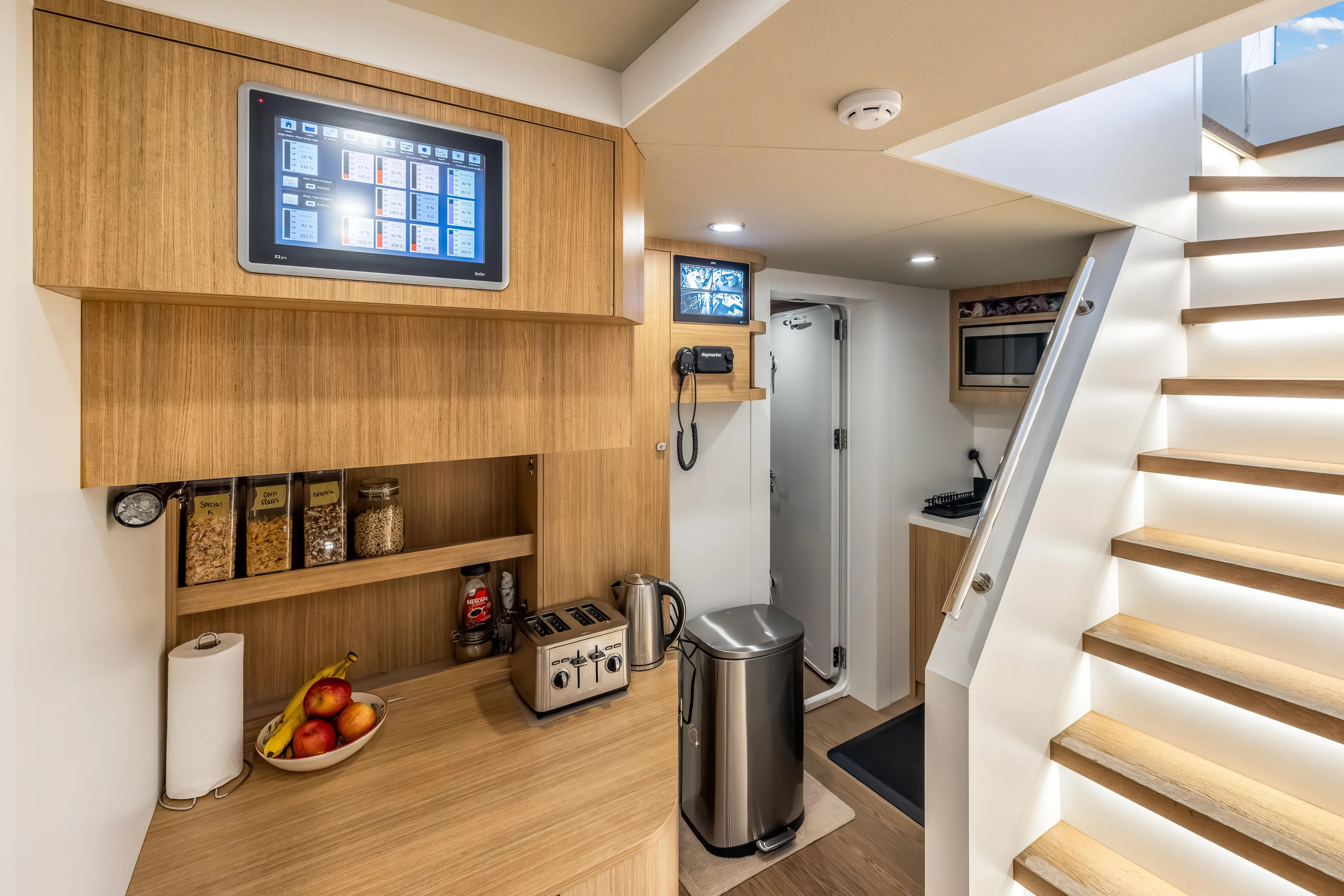 Evelyn P Yacht Photos Pics Modern kitchen area on 2022 Numarine 37XP yacht with wooden cabinetry and sleek appliances.