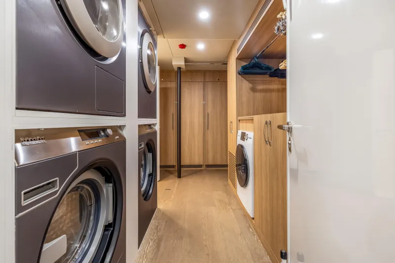 Evelyn P Yacht Photos Pics Laundry room on 2022 Numarine 37XP yacht with modern appliances and wooden cabinetry.