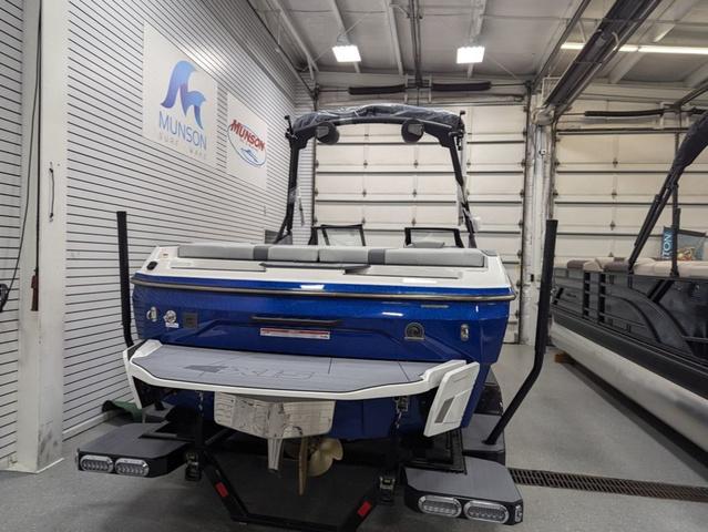 2025 Axis A225 boat in showroom, blue exterior, Munson signage in background.