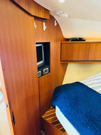 Why Knot Yacht Photos Pics 2007 Tiara Yachts 3900 Sovran cabin interior with wooden cabinetry and built-in TV.