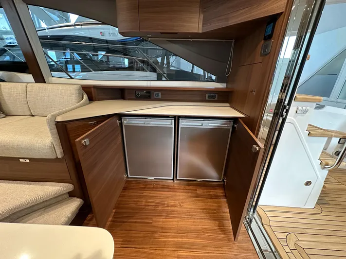 F45110 Yacht Photos Pics 2024 Princess F45 yacht interior with wooden cabinetry and dual stainless steel refrigerators.