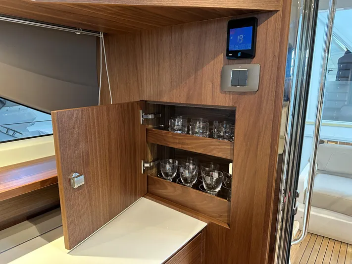 F45110 Yacht Photos Pics 2024 Princess F45 yacht interior with wooden cabinet and glassware storage.
