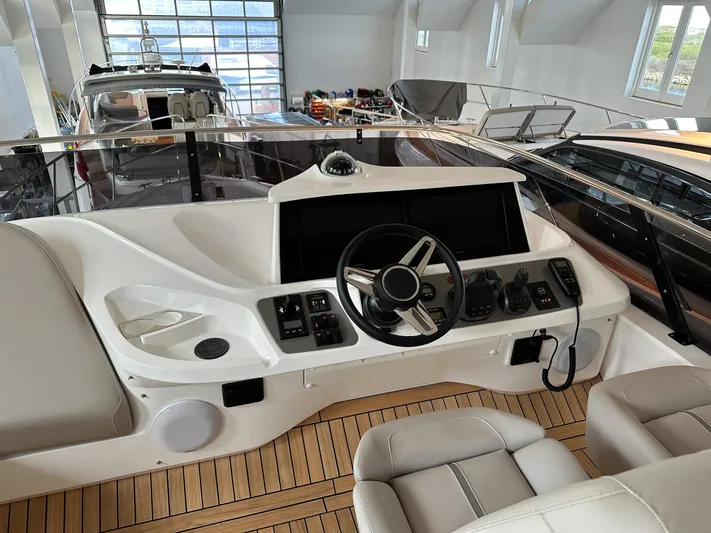 F45110 Yacht Photos Pics 2024 Princess F45 yacht helm with modern controls and luxurious seating in a showroom.