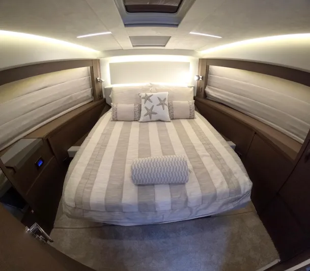  Yacht Photos Pics Luxurious bedroom interior of 2019 Prestige 520 yacht with striped bedding and starfish pillows.