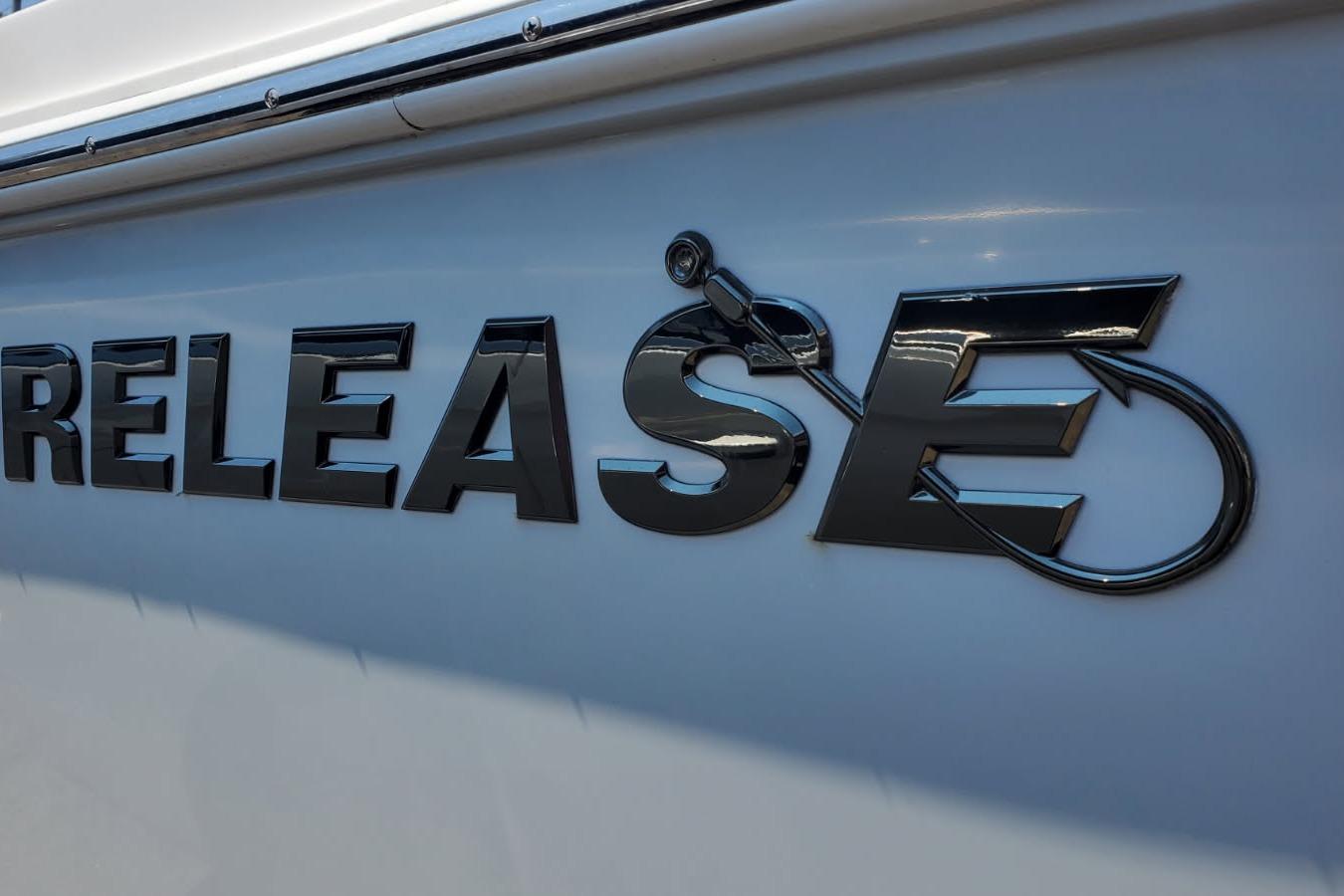 Close-up of 2018 Release 208RX boat logo with fishing hook design.