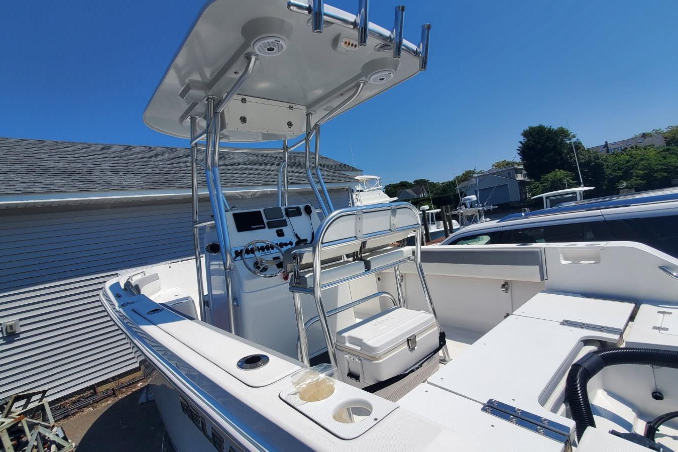 2018 Release 208RX boat with T-top and console, docked under clear blue sky.