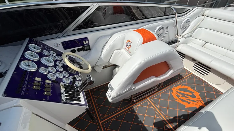  Yacht Photos Pics 2003 Fountain 47 Lightning boat interior with white and orange seating, control panel, and gauges.