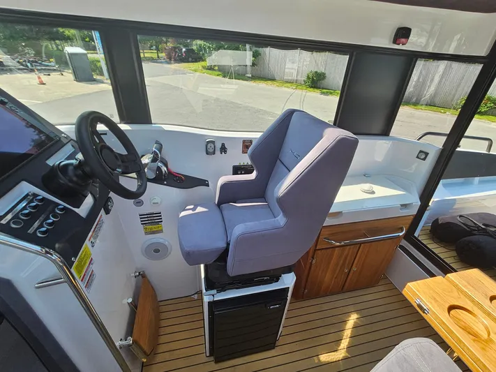 Yacht Photos Pics 2023 XO Boats EXPLR 10 Sport Plus cockpit with steering wheel and captain's chair.