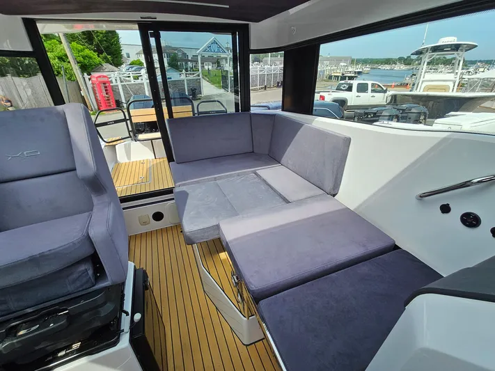  Yacht Photos Pics 2023 XO Boats EXPLR 10 Sport Plus interior with grey seating and wooden flooring.