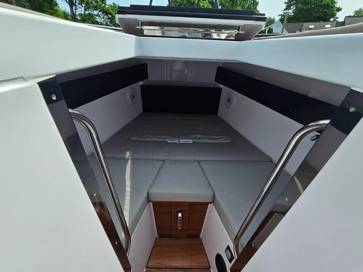  Yacht Photos Pics 2023 XO Boats EXPLR 10 Sport Plus cabin interior with cushioned seating and wooden flooring.