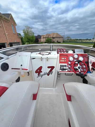  Yacht Photos Pics 2004 Fountain 47 Lightning boat cockpit with red and white interior, gauges, and steering wheel.