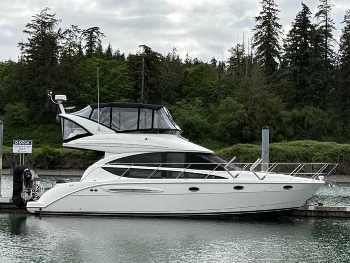  Yacht Photos Pics 2006 Meridian 391 Sedan yacht docked by a forested shoreline.