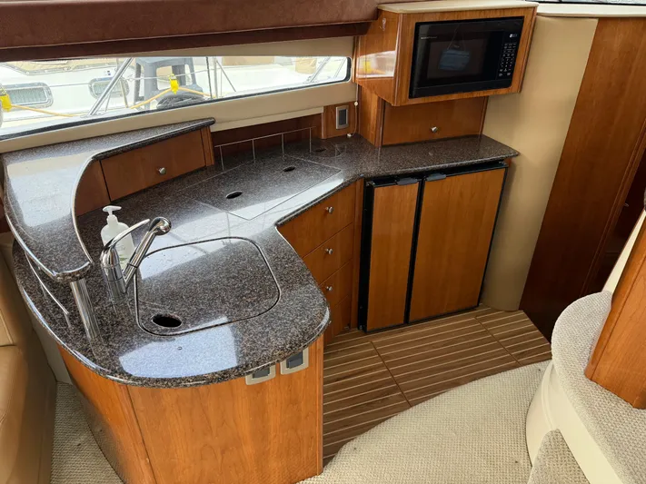  Yacht Photos Pics 2006 Meridian 391 Sedan yacht kitchen with granite countertops, sink, microwave, and wood cabinetry.