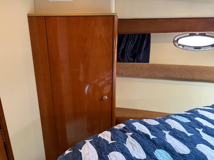  Yacht Photos Pics 2006 Meridian 391 Sedan interior with wooden cabinet and nautical-themed bedding.