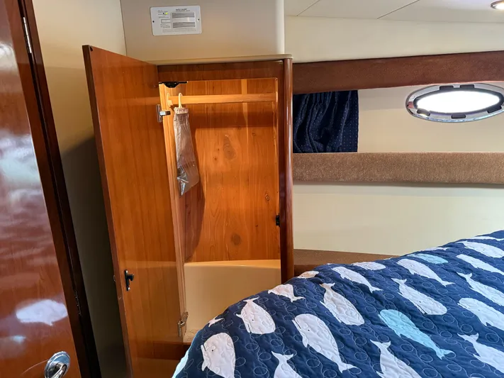  Yacht Photos Pics Interior of 2006 Meridian 391 Sedan with open wooden closet and fish-patterned bedspread.