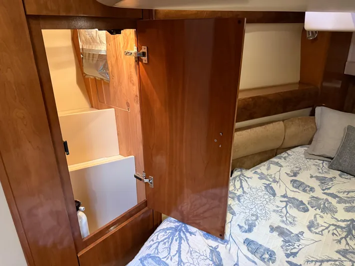  Yacht Photos Pics Interior of a 2006 Meridian 391 Sedan with open wooden cabinet and bed.