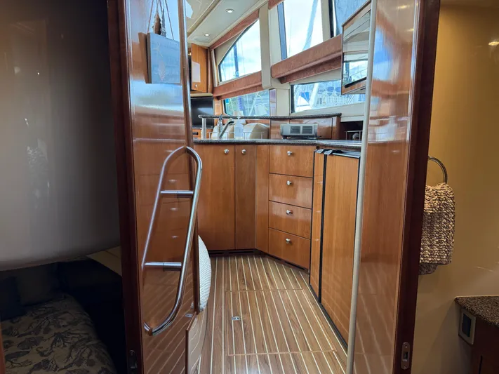  Yacht Photos Pics Interior view of 2006 Meridian 391 Sedan yacht kitchen with wood cabinetry and modern appliances.