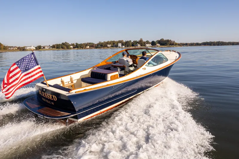 Blessed Yacht Photos Pics 2003 Hinckley Talaria 29 Runabout cruising on a calm lake with American flag.