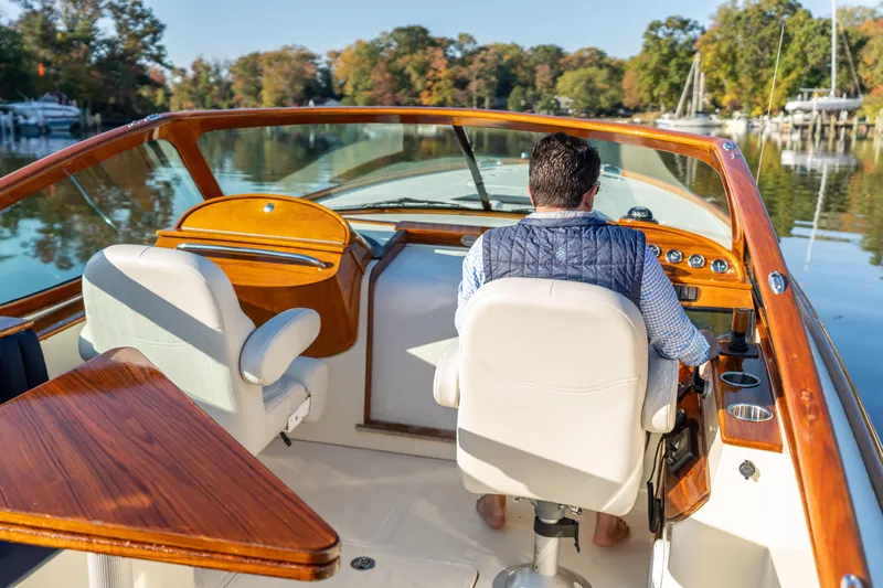Blessed Yacht Photos Pics Man steering 2003 Hinckley Talaria 29 Runabout on a calm river.