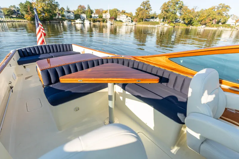 Blessed Yacht Photos Pics 2003 Hinckley Talaria 29 Runabout interior with blue seating and wooden table on calm water.