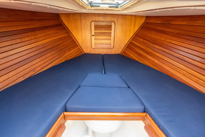 Blessed Yacht Photos Pics Interior cabin of 2003 Hinckley Talaria 29 Runabout with blue cushions and wooden paneling.