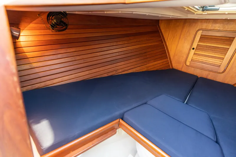 Blessed Yacht Photos Pics Interior cabin of 2003 Hinckley Talaria 29 Runabout with wooden paneling and blue cushions.