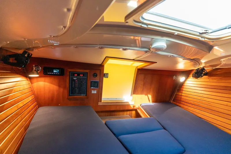 Blessed Yacht Photos Pics Cabin interior of 2003 Hinckley Talaria 29 Runabout with wood paneling and blue cushions.