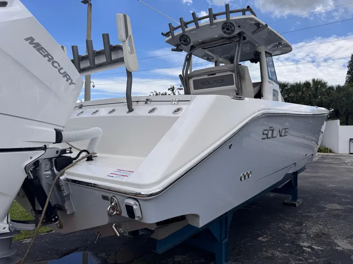 Call Today! 32 #55 Yacht Photos Pics 2025 Solace 32 CS boat with Mercury engine, docked outdoors under a partly cloudy sky.