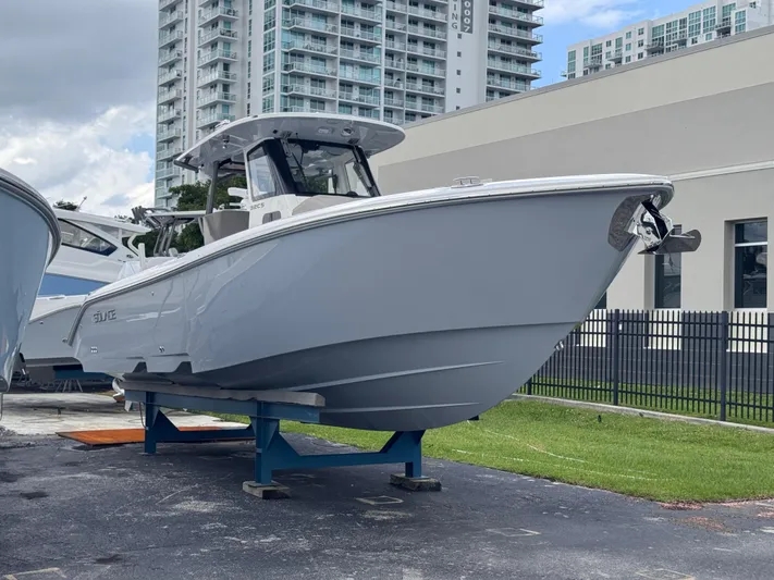 Call Today! 32 #55 Yacht Photos Pics 2025 Solace 32 CS boat displayed outdoors near modern buildings.