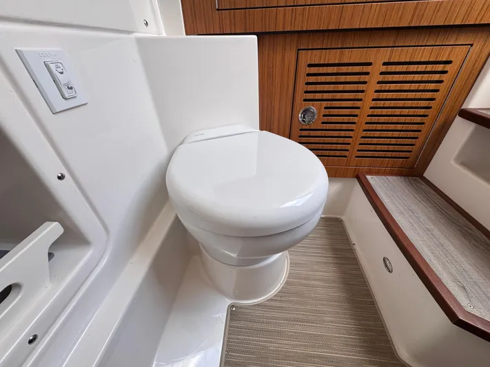 Call Today! 32 #55 Yacht Photos Pics 2025 Solace 32 CS boat interior with modern toilet and wooden cabinetry.