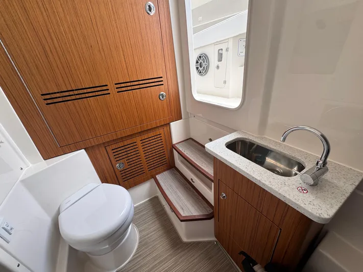 Call Today! 32 #55 Yacht Photos Pics 2025 Solace 32 CS boat interior with wooden cabinetry, sink, and toilet.
