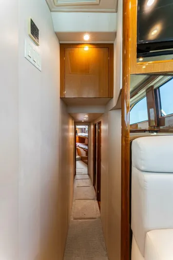 Wound Tight Yacht Photos Pics Narrow hallway inside 2004 Viking 48 Convertible yacht, featuring wooden cabinetry and plush seating.