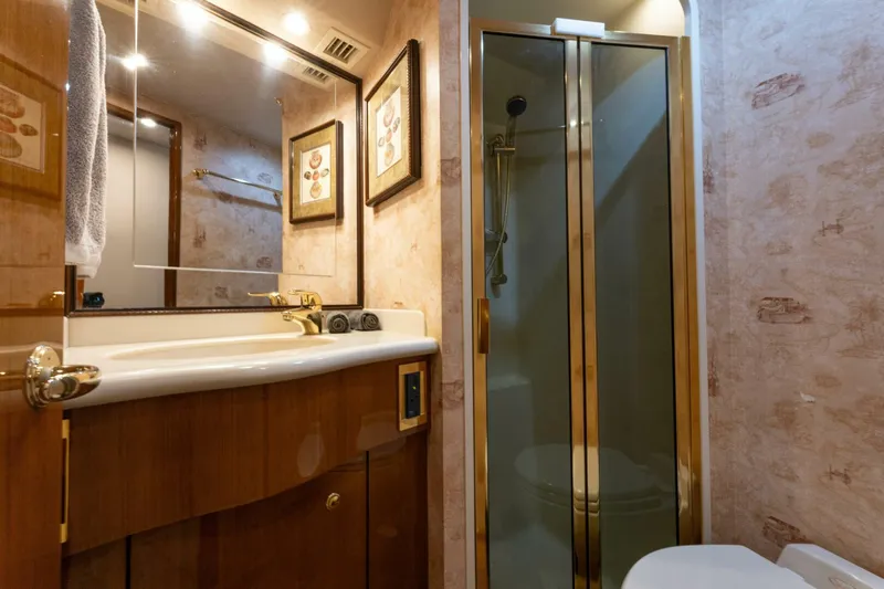 Wound Tight Yacht Photos Pics Luxurious bathroom in 2004 Viking 48 Convertible yacht with glass shower and elegant fixtures.