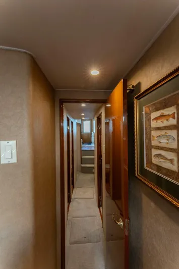 Wound Tight Yacht Photos Pics Hallway inside 2004 Viking 48 Convertible yacht, featuring framed fish artwork and carpeted flooring.