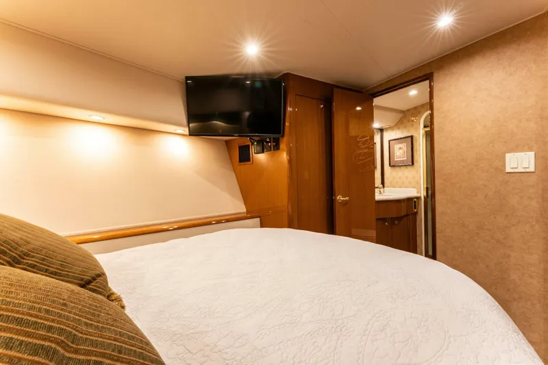 Wound Tight Yacht Photos Pics Luxurious bedroom interior of 2004 Viking 48 Convertible yacht with TV and ensuite bathroom.