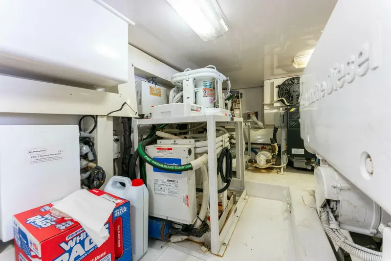 Wound Tight Yacht Photos Pics Engine room of 2004 Viking 48 Convertible yacht, featuring mechanical equipment and storage items.