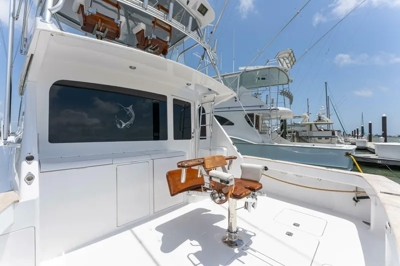 Wound Tight Yacht Photos Pics 2004 Viking 48 Convertible yacht with fishing chair, docked at marina under clear blue sky.