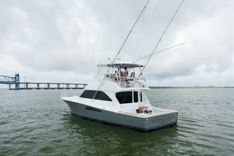 Wound Tight Yacht Photos Pics 2004 Viking 48 Convertible yacht on water near a bridge under cloudy skies.