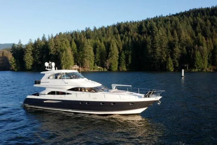 Jugni Yacht Photos Pics 2003 Viking Princess 65 yacht cruising on a serene lake with forested backdrop.