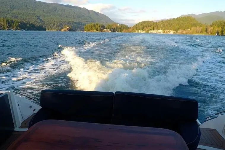 Jugni Yacht Photos Pics A 2003 Viking Princess 65 yacht cruising on a scenic lake with mountainous backdrop.