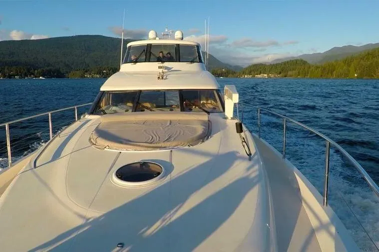 Jugni Yacht Photos Pics Luxurious 2003 Viking Princess 65 yacht cruising on a scenic lake with mountainous backdrop.