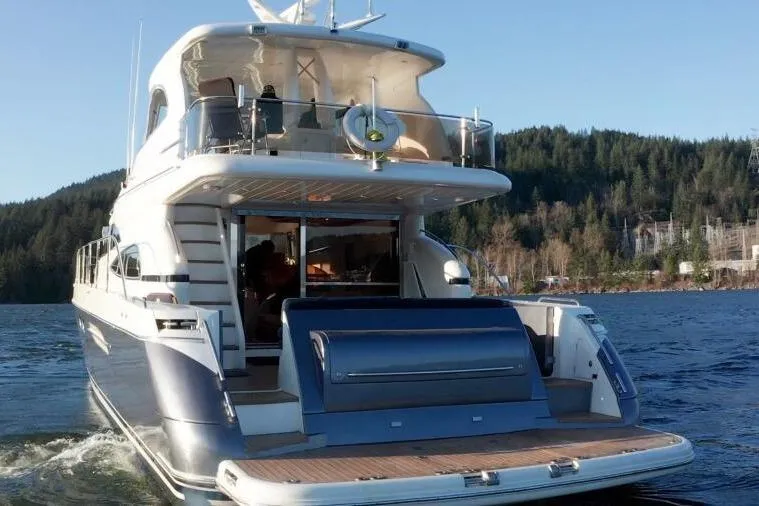 Jugni Yacht Photos Pics Luxury 2003 Viking Princess 65 yacht on serene water with forested backdrop.