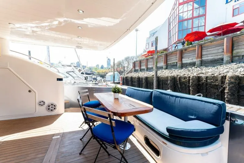 Jugni Yacht Photos Pics Luxurious 2003 Viking Princess 65 yacht deck with seating and table, docked at marina.