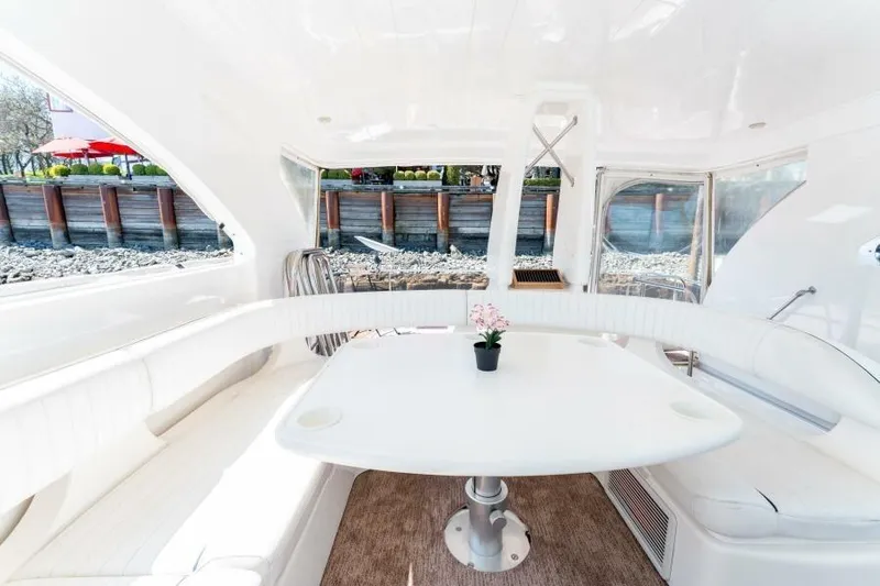 Jugni Yacht Photos Pics Luxurious interior of 2003 Viking Princess 65 yacht with elegant white seating and table.