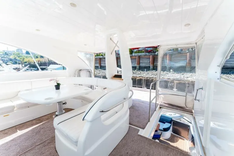 Jugni Yacht Photos Pics Luxurious 2003 Viking Princess 65 yacht interior with elegant white seating and table.